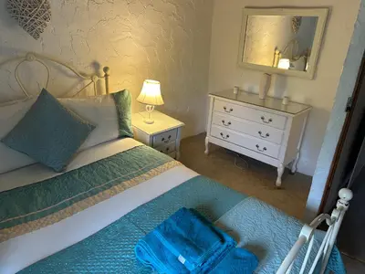 a bedroom with a bed and a dresser and a mirror at Oronsay, 2 Weint End Cottages, Great Urswick, Ulverston Cumbria LA120SP in Moffat