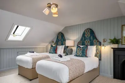 two beds in a room with blue and white at The Allan Maisonette Charming Georgian Retreat in Stirling
