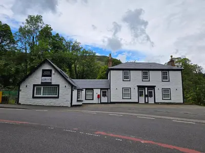 a white building on the side of a street at The Tearoom Tarbet in Tarbet