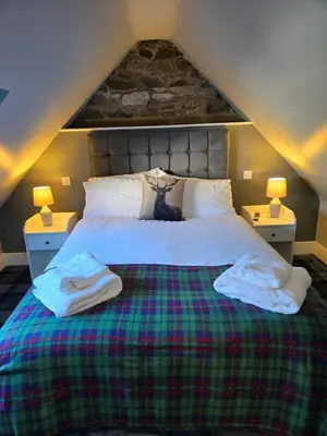 a bedroom with a large bed with two lamps at The Tearoom Tarbet in Tarbet