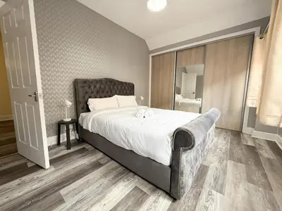 a bedroom with a large bed and a bathroom at Glasgow Home Newly Refurbished in Glasgow