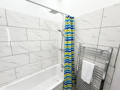a bathroom with a tub and a shower curtain at Glasgow Home Newly Refurbished in Glasgow