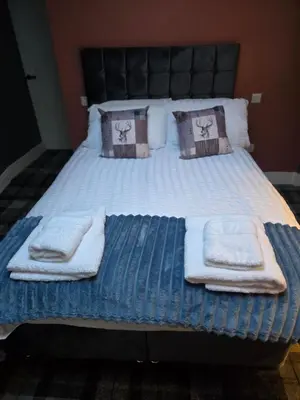 a bed with towels and pillows on it at The Post Office Tarbet in Tarbet