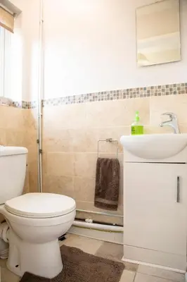 a bathroom with a toilet and a sink at 70 Abbotsbury Road, Bury St Edmunds, IP33 2HP in Moffat