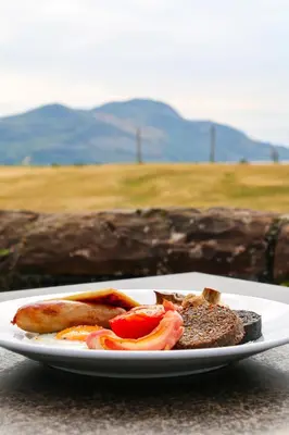 a plate of food with bacon and bread on a table at Glenisle Hotel in Isle of Arran
