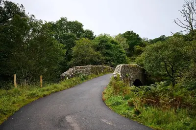 a road with a stone bridge over a road at Rural 1-Bed Retreat at Stunning Raera Farm in Kilninver