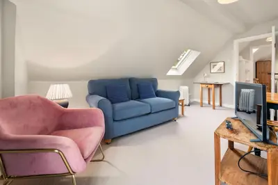 a living room with a blue couch and a tv at Rural 1-Bed Retreat at Stunning Raera Farm in Kilninver