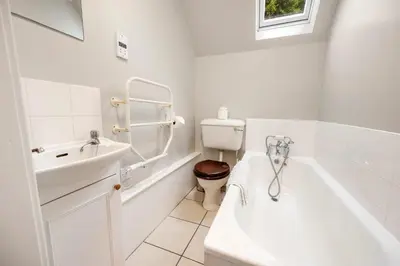 a white bathroom with a toilet and a tub and a sink at Rural 1-Bed Retreat at Stunning Raera Farm in Kilninver