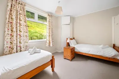 a bedroom with two beds and a window at Charming 2-Bed Cottage on Tranquil Raera Farm in Kilninver