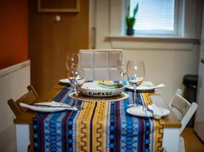 a table with a colorful table cloth and wine glasses at 3 bed, 500mtrs to castle and stunning views in Stirling