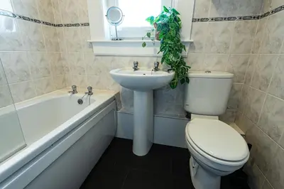 a bathroom with a toilet and a sink and a bath tub at 3 bed, 500mtrs to castle and stunning views in Stirling