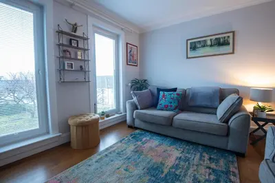 a living room with a couch and two windows at 3 bed, 500mtrs to castle and stunning views in Stirling