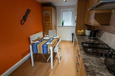 a small kitchen with a table and a counter top at 3 bed, 500mtrs to castle and stunning views in Stirling