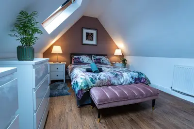 a bedroom with a bed and a chair and a window at 3 bed, 500mtrs to castle and stunning views in Stirling