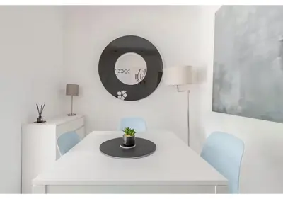 a white dining room with a white table and a mirror at Elegant Flat in a Serene Edinburgh Neighbourhood in Edinburgh