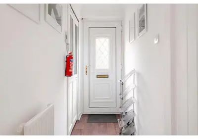 a hallway with a white door and a wooden floor at Elegant Flat in a Serene Edinburgh Neighbourhood in Edinburgh