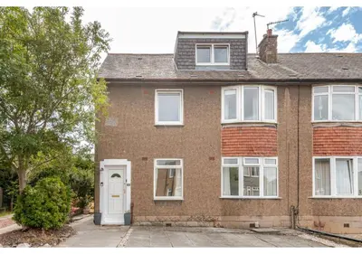 a brick house with a white door and windows at Elegant Flat in a Serene Edinburgh Neighbourhood in Edinburgh