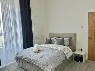 a bedroom with a bed with a white comforter at Three bedroom Apartment In Glasgow City Centre in Glasgow
