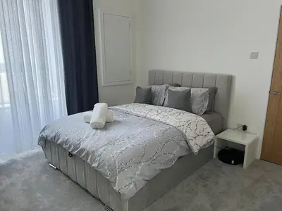 a bedroom with a bed with a teddy bear on it at Three bedroom Apartment In Glasgow City Centre in Glasgow