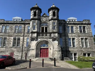 an old stone building with a red door at Skibo Vista Dunfermline in Dunfermline