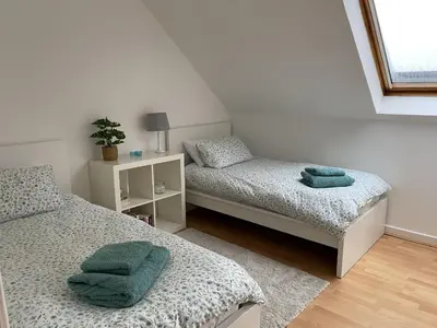 a bedroom with two beds with green towels on them at Skibo Vista Dunfermline in Dunfermline