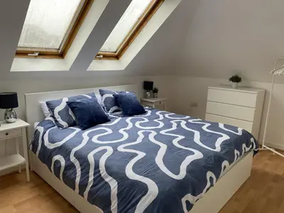 a bedroom with a bed with blue and white sheets at Skibo Vista Dunfermline in Dunfermline