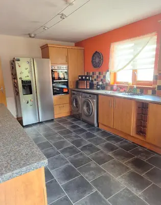 a kitchen with a refrigerator and a washer and dryer at The Yard Bungalow in Sanquhar