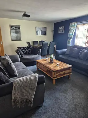 a living room with couches and a coffee table at The Yard Bungalow in Sanquhar