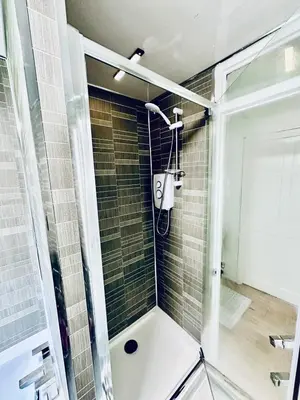 a shower with a glass door in a bathroom at 3 bedroom apartment in Cumbernauld