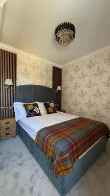 a bedroom with a bed and a chandelier at Armadillo Guest House- Adults Only in Edinburgh
