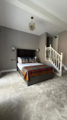 a bedroom with a bed and a chandelier at Armadillo Guest House- Adults Only in Edinburgh