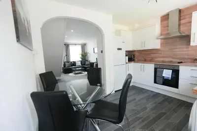 a kitchen and dining room with a glass table and chairs at Modern 2 Bedroom Platinum Pad Glasgow City in Glasgow