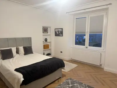 a white bedroom with a bed and a window at Stylish modern flat in the centre of Dunfermline in Dunfermline