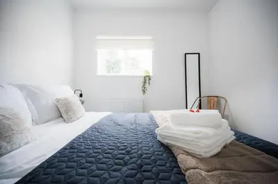 a bedroom with a bed with a blue blanket at 4 Bed Sheffield home in Moffat