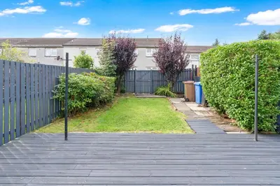 a wooden walkway in a yard with a fence at Livingston Retreat 4bed Home Wi-Fi Parking in Uphall