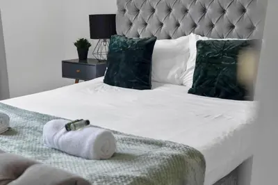 a bedroom with a bed with towels on it at Livingston Retreat 4bed Home Wi-Fi Parking in Uphall