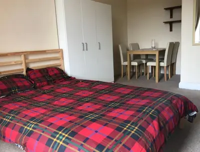 a bedroom with a bed and a table with chairs at Cosy, large double room in a shared flat in Edinburgh