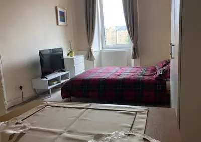 a bedroom with a bed and a tv in it at Cosy, large double room in a shared flat in Edinburgh