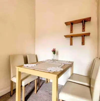 a table with chairs and a vase of flowers on it at Cosy, large double room in a shared flat in Edinburgh