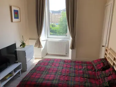 a bedroom with a bed and a large window at Cosy, large double room in a shared flat in Edinburgh