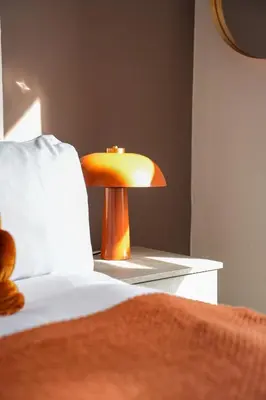 a yellow lamp sitting next to a bed in a room at Neilston Apartment in Paisley