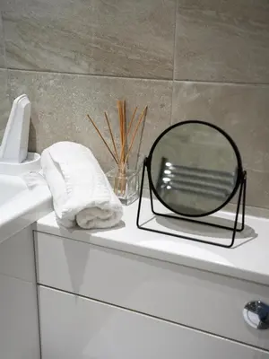 a mirror sitting on top of a white bath tub at Neilston Apartment in Paisley