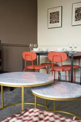 a group of tables and chairs in a restaurant at Neilston Apartment in Paisley