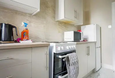 a kitchen with a stove and a microwave at Neilston Apartment in Paisley