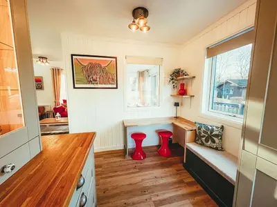 a kitchen with two red stools in a room at Highland Coo Lodge in Dunoon