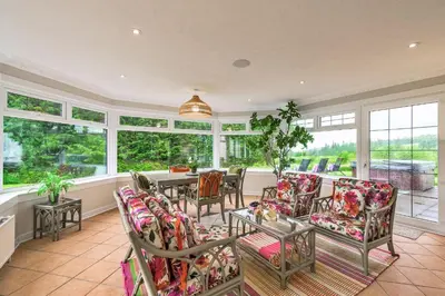 an empty living room with a table and chairs at Finest Retreats - Grassyards House in Largs