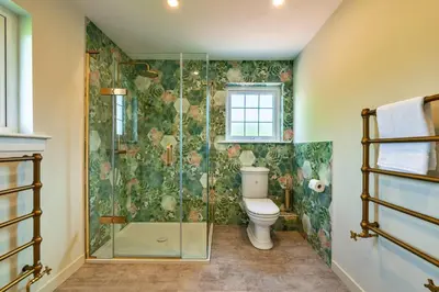 a bathroom with a toilet and a glass shower at Finest Retreats - Grassyards House in Largs
