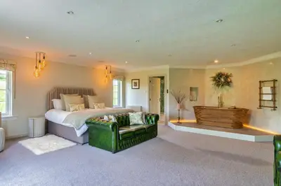 a bedroom with a bed and a green couch at Finest Retreats - Grassyards House in Largs