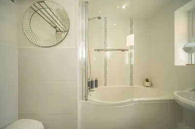 a bathroom with a tub and a toilet and a sink at Spacious 3 Bedroom home in Ascot, Sleeps 5, Parking in Moffat