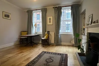 a living room with a table and a fireplace at Central and Spacious first floor flat in Moffat